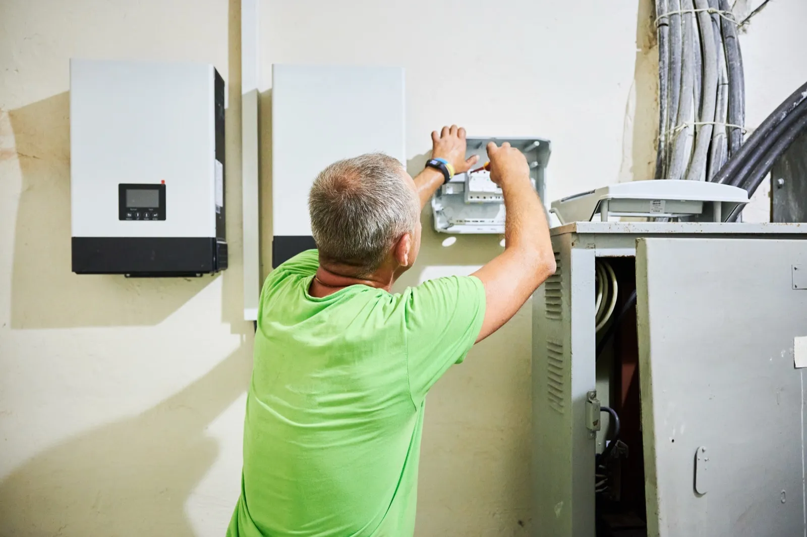 Elektryk podłącza falownik hybrydowy magazynu energii