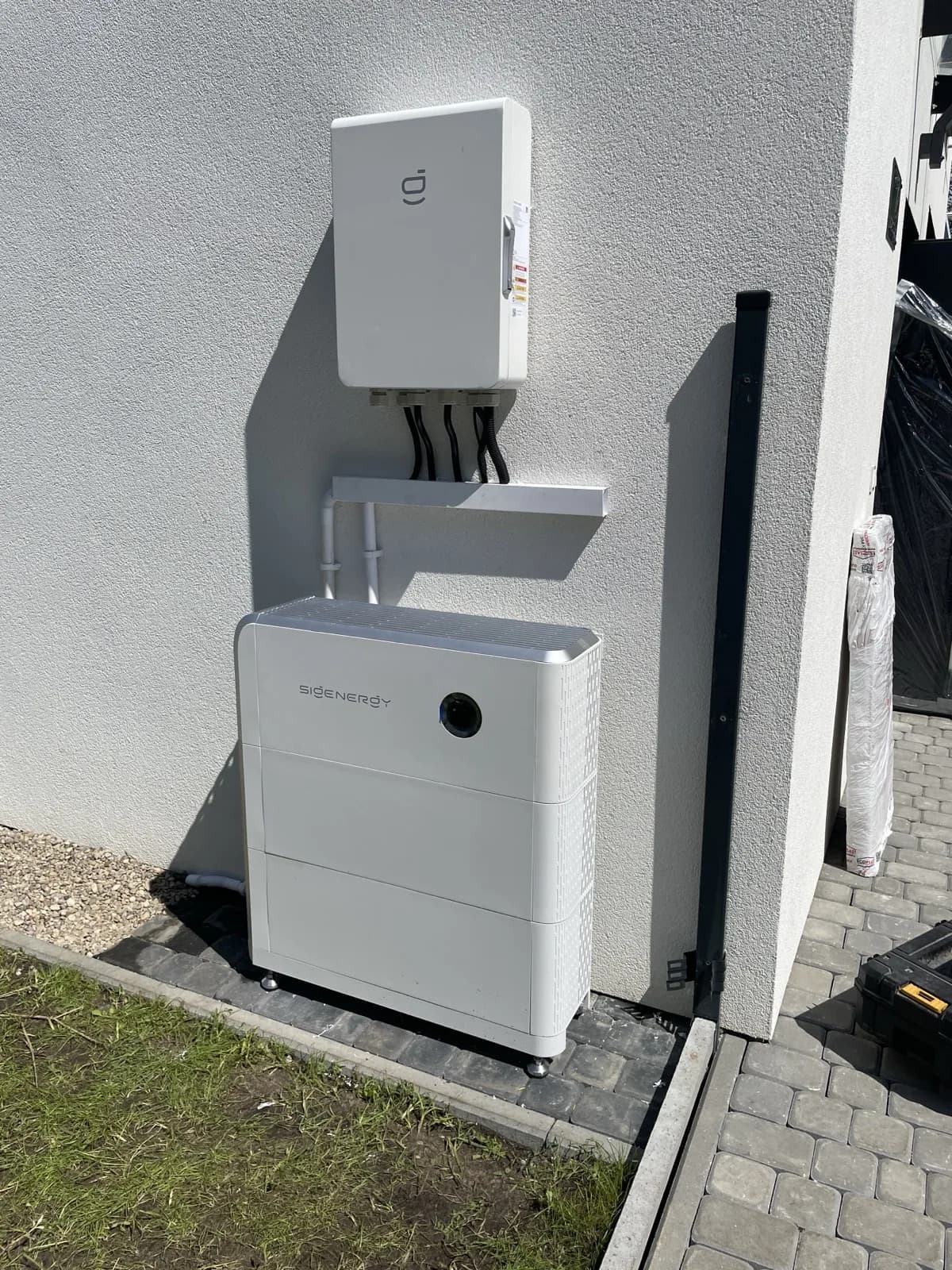 Sigenergy SigenStor postawiony na zewnątrz, przy ścianie budynku. Zwolnienie z art. 29 obejmuje także podłoże i konstrukcję pod urządzeniem. Realizacja NEXBE.